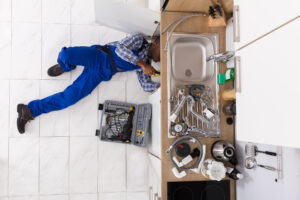 A technician servicing a kitchen sink